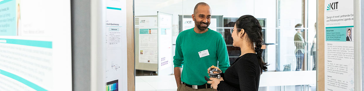 Researchers discussing a poster during the 2022 KSOP Summer School