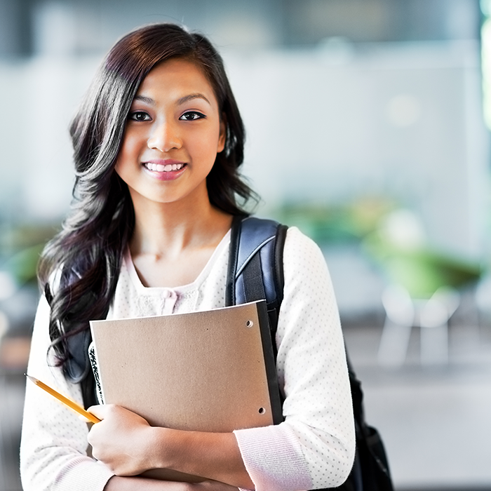 Woman student holding books and smiling